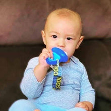 a baby sitting on a couch with a toothbrush